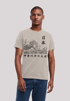 Beige katoenen t-shirt met een zwarte graphic van golven en Japanse tekst, ronde hals, korte mouwen en een ontspannen pasvorm.