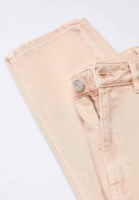 Jean en denim rose clair avec une fermeture par bouton et fermeture éclair, doté de poches latérales et d'un tissu texturé. L'ourlet est replié et soigneusement cousu.