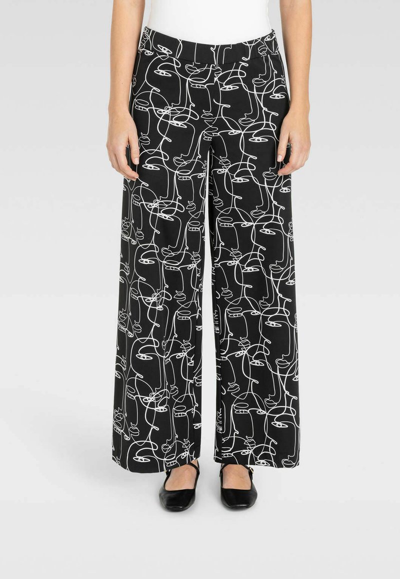 Pantaloni a gamba larga realizzati in tessuto morbido, con uno sfondo nero e un motivo di disegno a linee astratte bianche. Vita elastica per il massimo comfort.