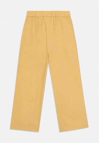 Gelbe weite Hosen aus weicher Baumwolle mit einem elastischen Bund, die eine glatte Textur aufweisen und keine sichtbaren Muster oder Akzente haben.