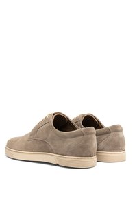 Helle Wildlederschuhe mit flachem Profil, abgerundeter Zehenpartie und leichten Gummisohlen. Mit genähten Akzenten und einer Lasche an der Rückseite. Schnürsenkel vorne.