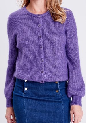 Lila stickad cardigan med rund halsringning, framknappstängning och långa, puffiga ärmar, tillverkad av mjukt, fluffigt material.