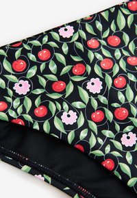 Melna auduma ar atkārtotu sarkano ķiršu, rozā un baltu ziedu, kā arī zaļo lapu rakstu. Gluda tekstūra; redzamas elastīgas malas.