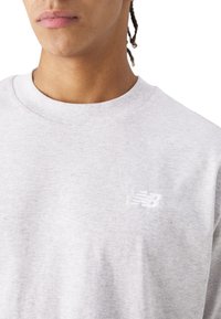 Sweatshirt gris à col rond, fabriqué en tissu doux. Doté d'un logo brodé blanc sur la poitrine. Design simple et classique.