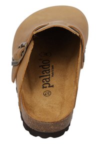 Tan leather slip-on clog with a brown textured cork sole, featuring a silver buckle accent and printed brand logo on the insole.