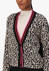 Leopardenmuster-Kardigan mit schwarzen, roten und pinken Streifenakzenten, ausgestattet mit schwarzen Knöpfen und einem V-Ausschnitt. Weiches Strickmaterial.
