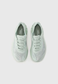 Chaussures de sport vert menthe avec un empeigne en mesh, lacets plats, côtés à motifs et semelles texturées. Design léger et respirant.
