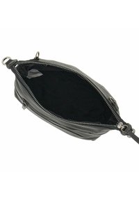 Bolso de piel negra con cierre de cremallera, que presenta una textura suave y un espacioso interior negro. Accesorios de metal y un diseño delgado.