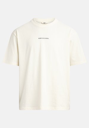 Trumpas rankovės, apvalios iškirptės marškinėliai off-white spalvos, pagaminti iš švelnios medvilnės. Priekyje centre yra juodu tekstu užrašas "REDEFINED REBEL".
