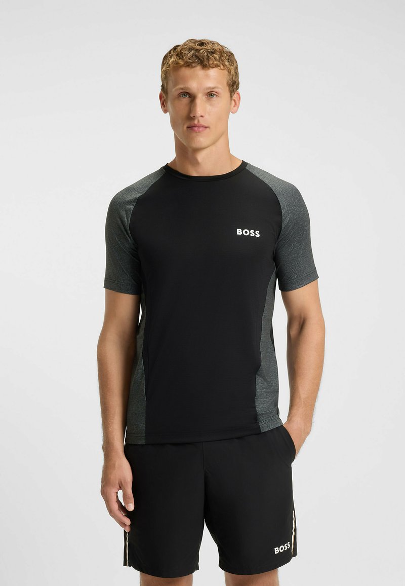 Svart idrottströja med korta ärmar, grå detaljer och "BOSS"-logotyp. Matchad med svarta shorts med logodetalj och sidostrickor.