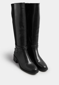 Czarne kozaki za kolano wykonane z błyszczącej skóry z zamszowym tyłem, z paskiem z klamrą i metalowymi akcentami oraz modestym obcasem w kształcie bloku.