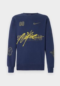 Modra dukserica iz bombaža z rumenimi grafikami, logotipom Nike in različnimi besedilnimi oblikovanji. Okroglo izrezana in z dolgimi rokavi.