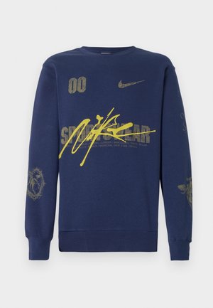 Felpa blu navy in cotone, con grafiche gialle, logo Nike e vari design testuali. Collo a giro e maniche lunghe.