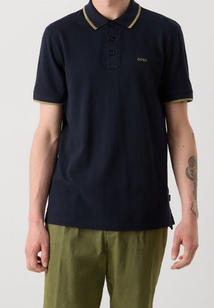 Polo bleu marine avec col et poignets jaune-vert contrastants ; patte de boutonnage à trois boutons ; marquage subtil sur la poitrine ; manches courtes ; tissu texturé.