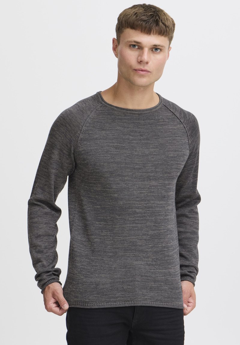 Sweatshirt à col ras du cou en gris foncé à manches longues, avec un tricot texturé, des manches raglan et une coupe décontractée. L'ourlet est cousu.