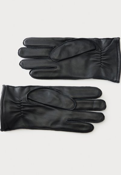 Paire de gants en cuir noir avec surpiqûres apparentes et élastique froncé au poignet, posés à plat sur fond blanc.