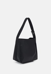 Borsa tote nera con una finitura liscia opaca, caratterizzata da una ampia tracolla impressa con il nome del marchio e un design strutturato e minimalista.