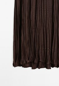 Jupe plissée marron foncé en tissu doux et fluide. Présente un ourlet froncé et des plis verticaux intriqués sur l'ensemble de la conception.