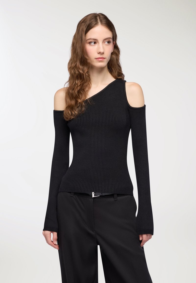 Czarny prążkowany sweter o asymetrycznym kroju bez ramiączek, z długimi dopasowanymi rękawami i teksturowanym wykończeniem, zestawiony z czarnymi spodniami.