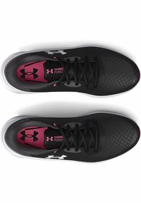 Chaussures de sport noires avec un dessus texturé, une doublure intérieure rose et des accents de logo blancs. Elles disposent de lacets plats et d'une semelle en caoutchouc arrondie.