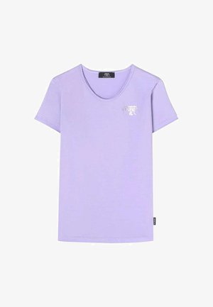 T-shirt lavande à manches courtes en coton doux. Présente un col en V et un petit logo argenté sur la poitrine. Coupe classique, décontractée.