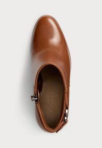 Bota de tornozelo em couro castanho com fivela lateral, acabamento liso, bico arredondado, e palmilha em relevo "Lauren Ralph Lauren", vista de cima.