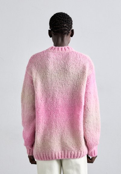 Pullover rosa lavorato a maglia con un design a gradiente, con scollatura e polsini a coste. La texture appare morbida e soffice, con punti allentati.