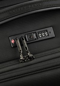 Valigia nera con superficie texturizzata, dotata di lucchetto a combinazione TSA, chiusure a doppia zip e marchio Delsey in accentuazioni metalliche.