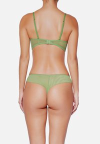 Ensemble de lingerie en maille verte avec bretelles ajustables, présentant un simple système de fermeture au dos et un design minimaliste. Texture douce, tissu transparent.