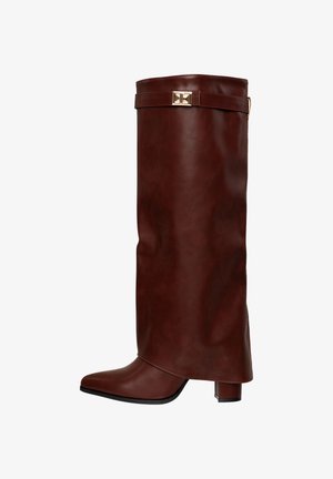 Braune Kunstleder-Stiefel bis zum Knie mit spitz zulaufender Zehenpartie und Blockabsatz. Verfügt über eine goldene Schnallenakzentuierung und eine elegante, glatte Textur.