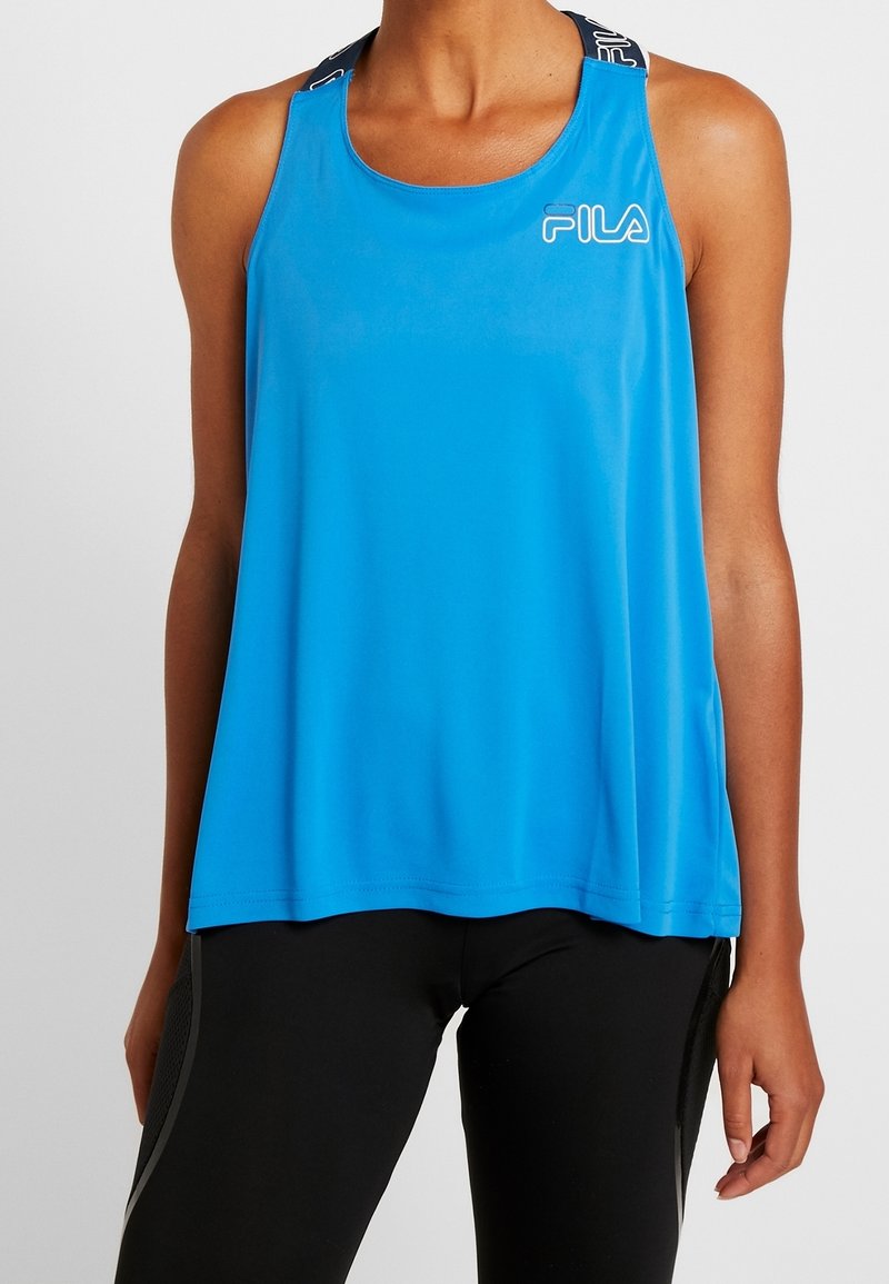 Blå ärmlös linne i lätt och slätt material. Har rund halsringning och märkta axelband med en Fila-logotyp på framsidan.
