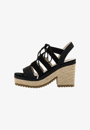 Sandalia cuña negra con punta abierta, cordones en la parte delantera, plataforma de fibras naturales tejidas y tacón ancho con suela texturizada.