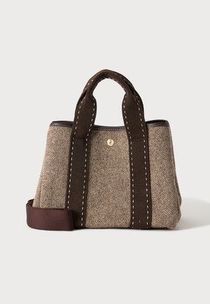 Lille beige og brun stoftaske med brede mørkebrune håndtag og en justerbar skulderrem på hvid baggrund.