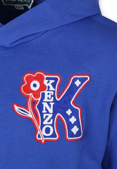 Haut à capuche bleu avec un logo "K" brodé accompagné d'une fleur rouge et d'accents blancs. Texture douce avec des poignets et un ourlet côtelés.