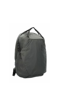 Sac à dos en tissu gris de forme rectangulaire, avec une poignée de transport sur le dessus, des sangles latérales ajustables et une finition texturée. Présente un logo sur le côté.