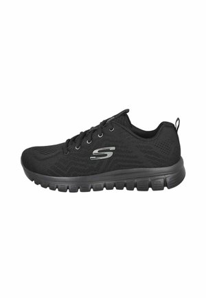Zapatilla deportiva negra con cierre de cordones en la parte delantera, parte superior de malla, suela acolchada y logotipo plateado en forma de S en el lateral.