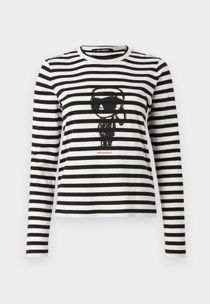 Μακρυμάνικη μπλούζα με ρίγες σε μαύρο και άσπρο από βαμβάκι. Διαθέτει κεντρικό γραφικό με χαρακτήρα που φοράει γυαλιά ηλίου, με την επιγραφή "Karl Lagerfeld" από κάτω.