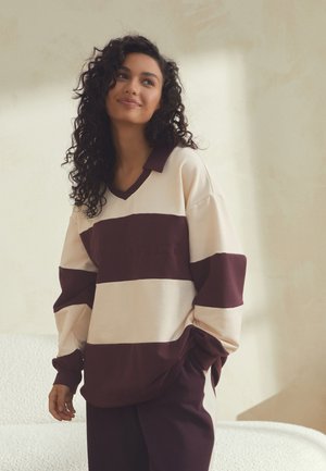 Stor sweatshirt i vinrød og creme med striber, V-udskæring og krave, med et struktureret design og prægede bogstaver.