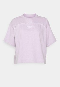 Jasnofioletowa, oversize'owa koszulka wykonana z miękkiego materiału, z okrągłym dekoltem, krótkimi rękawami i białym logo Reebok z przodu.