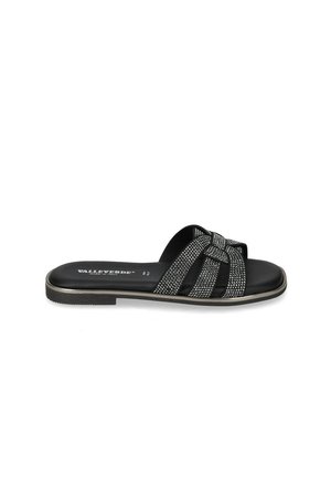 Sandalo flat nero con cinturini incrociati decorati con piccole borchie argento e suola sottile con nome del marchio visibile all'interno.