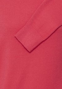 Pull en maille corail avec des poignets côtelés et une texture douce, doté d'une finition lisse et d'une coupe légèrement ample.