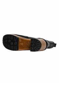 Black leather boot with a rubber sole featuring a textured grip pattern and a curved heel. Includes a contrasting tan accent on the heel.