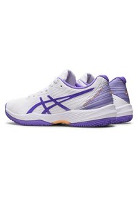 Baskets de tennis blanches avec des accents violets, présentant un dessus texturé, un talon renforcé et un motif en vagues sur la semelle extérieure pour une meilleure adhérence.