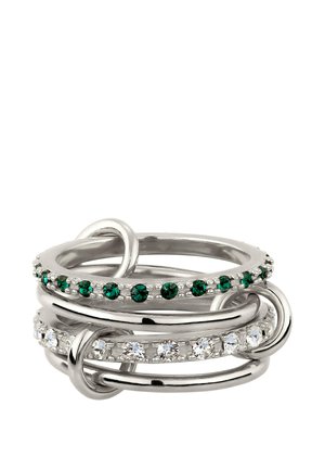 Silberne ineinandergreifende Ringe mit zwei Bändern, die abwechselnd mit grünen und klaren runden Edelsteinen besetzt sind, auf weißem Hintergrund.