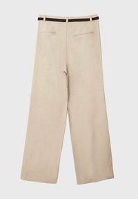 Pantalon beige à jambes larges en tissu doux, avec une ceinture tressée marron et deux poches arrière au design simple et aux bords nets.