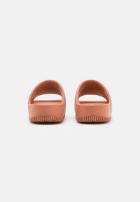 Rubber clogs with a smooth, matte finish; soft peach color; contoured footbed; open back design; textured sole for grip.