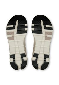 Barna és fekete textúrájú talpú bézs és fehér sportcipők, amelyek elülső részén "CloudTec" feliratozás látható.