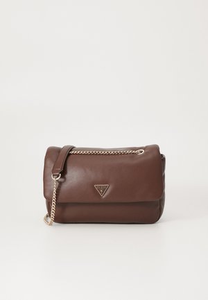 Bruine leren Guess-handtas met klepsluiting en gouden kettingriem op een effen witte achtergrond.