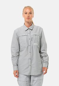 Hellgrau gestreifte Hemdbluse mit langen Ärmeln, zwei Brusttaschen und Logo; glatte Stofftextur und lockerer Schnitt für Komfort.