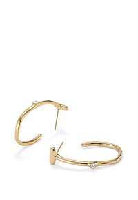 Boucles d'oreilles en or avec un design courbé, comportant un petit accent en diamant sur chaque boucle et une texture lisse et polie.